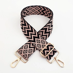 Close-up of 5cm pink and black geometric pattern bag strap with gold metal buckle