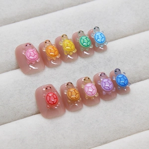 Handmade cat eye press-on nails featuring 3D colorful crystal turtles in rainbow colors