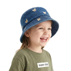 Détail d'un chapeau bob en denim pour enfant avec broderie d'ours jaune