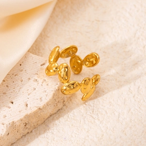 Macro shot of 18K gold plated textured oval link ring on a natural beige stone