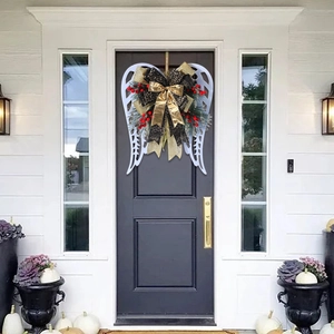 Christmas angel wing wreath with festive bow and greenery for front door decoration