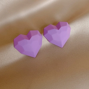 Elegant purple heart-shaped stud earrings with geometric faceted design on gold satin background