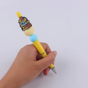 DIY yellow beaded ballpoint pen with 'All you need is Love' cartoon silicone decoration
