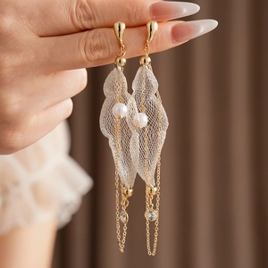 Detailansicht eleganter goldener Tropfenohrringe mit Netzhautblättern und weißen Perlen