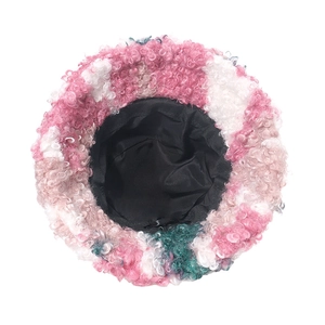 Top view of pink white and green curly faux shearling bucket hat with black lining