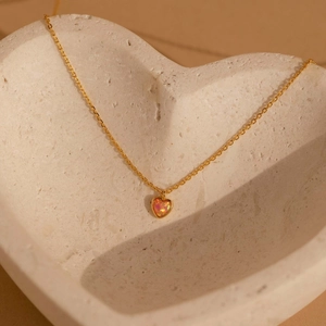 Elegant gold heart pendant necklace with pink fire opal inlay in a heart-shaped tray