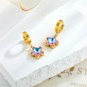 Gold star drop earrings with gradient purple and blue crystals on marble stand