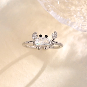 Creative silver crab ring with sparkling crystals and adjustable band on a warm background
