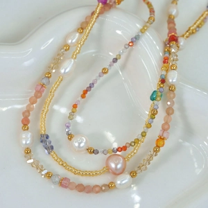 Macro detail of colorful natural stone beads and freshwater pearls on a layered necklace