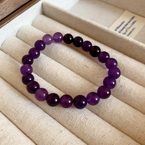 Detailed view of polished purple crystal beads on a velvet jewelry display tray