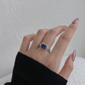 Close-up of S925 sterling silver ring featuring a blue cushion-cut gemstone on model finger