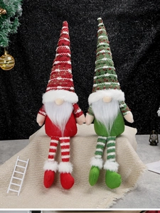 Detail of Nordic knitted Christmas gnomes with long striped legs on burlap surface