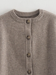 Detail of amber texture buttons on a mocha brown knit cardigan with a classic round neck
