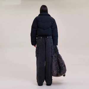Back view of short black down jacket and grey wide-leg cargo jeans with fur bag
