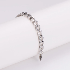 Polished silver stainless steel cuban chain bracelet with lobster clasp on white stand