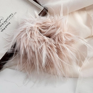 Close-up of plush beige faux fur hair tie showing soft texture and premium materials