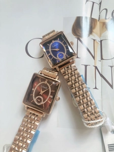 Detailed shot of two luxury square wristwatches with rose gold bands on a fashion magazine