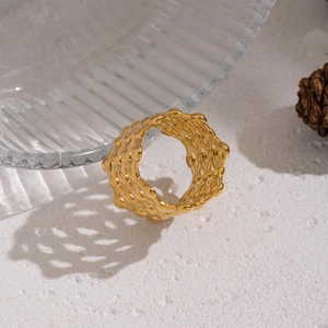 Makro-Detail des breiten goldfarbenen Rings mit gewebter Edelstahl-Gitterstruktur