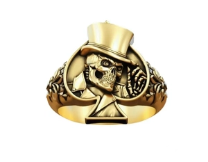 Gros plan sur la bague tête de mort vintage dorée avec chapeau et cadre pique