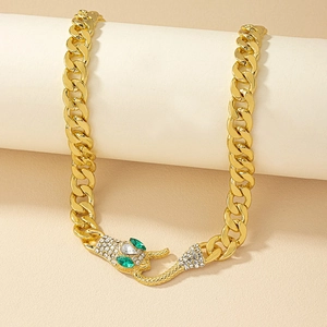 Gold Cuban chain necklace with sparkling snake head clasp featuring green gemstone eyes
