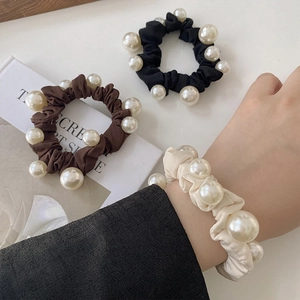 Vue détaillée des chouchous élastiques avec de grosses perles en noir, marron et beige