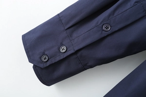 Detail view of navy cotton poplin shirt cuff with two circular buttons and neat stitching