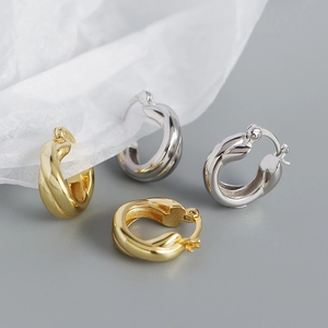 Close-up of twisted S925 silver hoop earrings in both gold and silver finishes