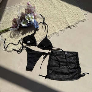 Vue détaillée du bikini noir scintillant avec jupe en maille à cordon de serrage