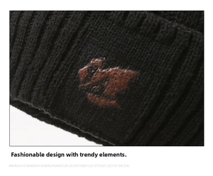 Close-up of black ribbed knit beanie with brown faux leather patch and textured detailing