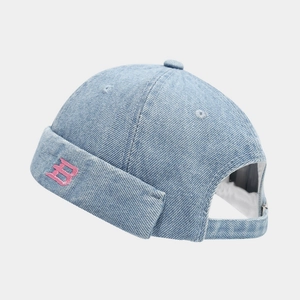 Close-up of light blue denim docker hat with pink B embroidery and adjustable back strap