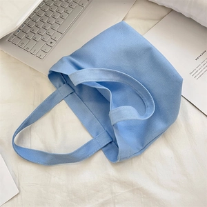 Close-up of light blue canvas tote bag showing fine texture on a white background