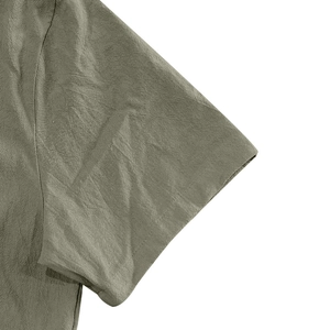 Close-up of olive green linen shirt sleeve showing natural fiber texture and stitching
