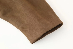 Close-up of deep brown suede bomber jacket cuff showing premium soft texture