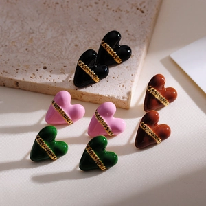 Close-up of heart-shaped earrings with gold chain in black, pink, green, and brown