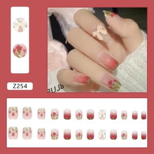 Press-on nails featuring gradient pink base with tulip floral art and white 3D bows