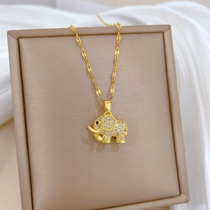Titanium gold elephant necklace with micro-pave crystals on soft white silk background