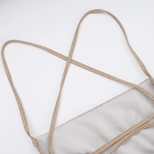 Detail view of sparkly silver dress with cross-back metallic gold shoulder straps