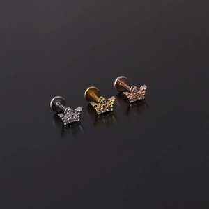 Close-up of crown lip studs in silver, gold and rose gold with zircon inlay