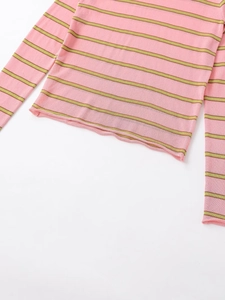 Detailed view of pink and green horizontal stripes on thin knit long sleeve sweater