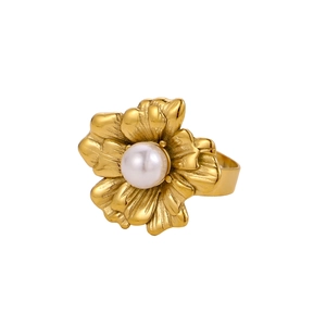 Close-up of vintage gold flower ring with pearl center and wide textured band