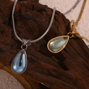 Close-up of gold and silver snake chains with blue and green water drop pendants