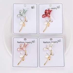 Detail of four colorful flower brooches with matte metal finish and pearl center