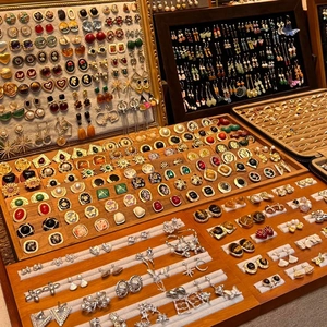 Detailed display of vintage earrings and rings in organized wooden jewelry boxes