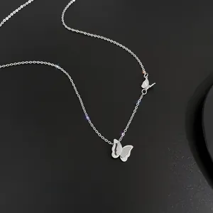 Macro detail of silver double butterfly necklace with frosted texture and glitter finish