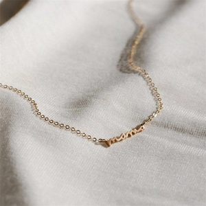 Dettaglio della collana con ciondolo mama in oro e catenina sottile da donna