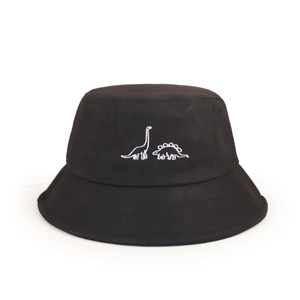 Détail de la broderie de dinosaure blanc sur un chapeau bob noir pour enfants