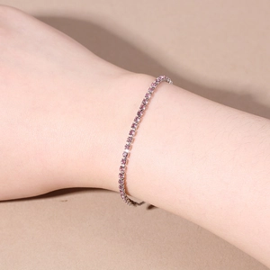 Detail view of a 2.5mm pink cubic zirconia tennis bracelet on a female wrist