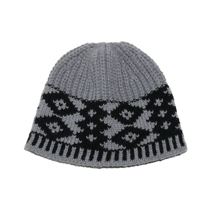 Detailed view of dark grey knitted hat featuring black geometric jacquard pattern weave