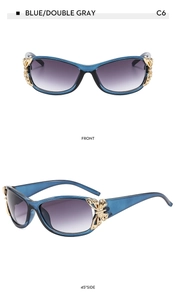 Close-up of blue rectangular sunglasses with golden butterfly metal accent and gray lenses
