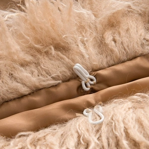 Detail shot of camel faux fur jacket showing high-quality buckles and soft texture